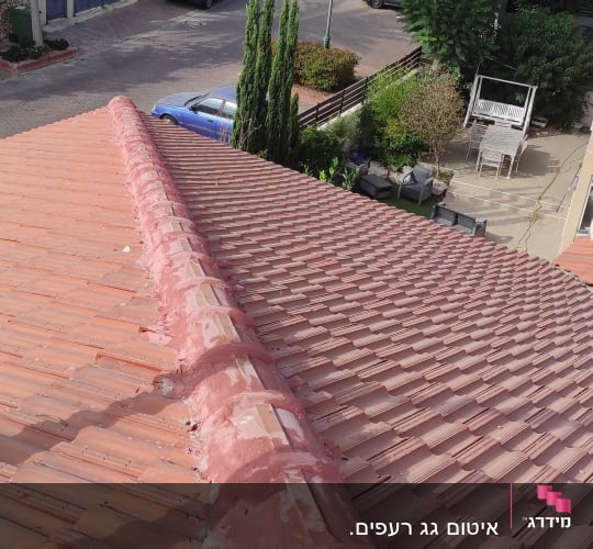 גג רעפים עם חומר איטום ורוד לאורך החיבור